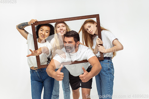 Image of Group of adorable multiethnic friends having fun isolated over white studio background