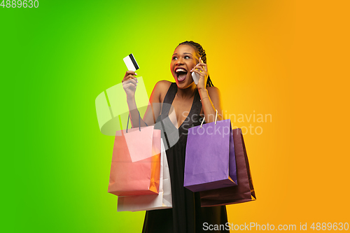 Image of Portrait of young woman in neon light on gradient backgound. The human emotions, black friday, cyber monday, purchases, sales, finance concept.