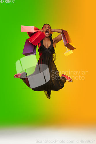 Image of Portrait of young woman in neon light on gradient backgound. The human emotions, black friday, cyber monday, purchases, sales, finance concept.