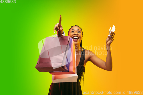 Image of Portrait of young woman in neon light on gradient backgound. The human emotions, black friday, cyber monday, purchases, sales, finance concept.