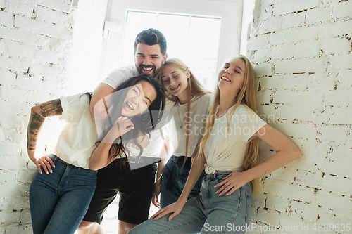 Image of Group of adorable multiethnic friends having fun at home interior background