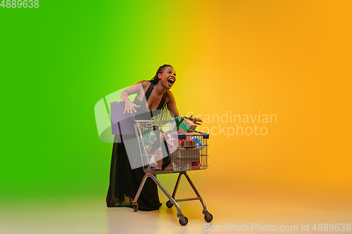 Image of Portrait of young woman in neon light on gradient backgound. The human emotions, black friday, cyber monday, purchases, sales, finance concept.