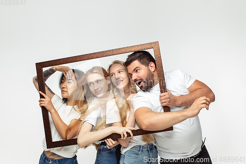 Image of Group of adorable multiethnic friends having fun isolated over white studio background