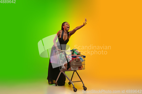 Image of Portrait of young woman in neon light on gradient backgound. The human emotions, black friday, cyber monday, purchases, sales, finance concept.