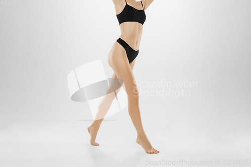 Image of Beautiful female legs and belly isolated on white background. Beauty, cosmetics, spa, depilation, treatment and fitness concept.