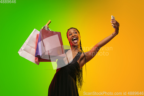 Image of Portrait of young woman in neon light on gradient backgound. The human emotions, black friday, cyber monday, purchases, sales, finance concept.