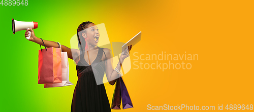 Image of Portrait of young woman in neon light on gradient backgound. The human emotions, black friday, cyber monday, purchases, sales, finance concept.