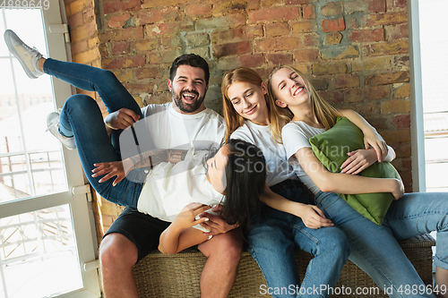 Image of Group of adorable multiethnic friends having fun at home interior background