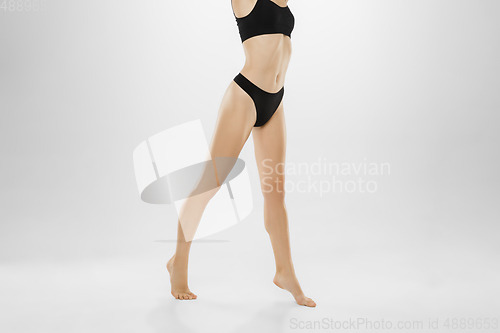 Image of Beautiful female legs and belly isolated on white background. Beauty, cosmetics, spa, depilation, treatment and fitness concept.
