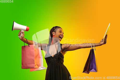 Image of Portrait of young woman in neon light on gradient backgound. The human emotions, black friday, cyber monday, purchases, sales, finance concept.