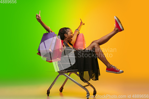 Image of Portrait of young woman in neon light on gradient backgound. The human emotions, black friday, cyber monday, purchases, sales, finance concept.