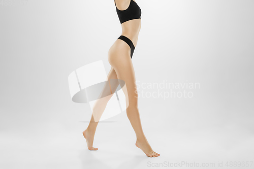 Image of Beautiful female legs and belly isolated on white background. Beauty, cosmetics, spa, depilation, treatment and fitness concept.