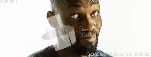 Image of African-american young man\'s close up shot on studio background, flyer