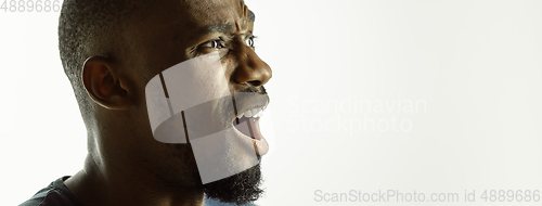 Image of African-american young man\'s close up shot on studio background, flyer