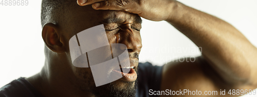 Image of African-american young man\'s close up shot on studio background, flyer