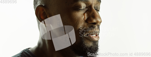 Image of African-american young man\'s close up shot on studio background, flyer
