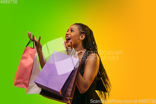 Image of Portrait of young woman in neon light on gradient backgound. The human emotions, black friday, cyber monday, purchases, sales, finance concept.