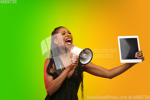 Image of Portrait of young woman in neon light on gradient backgound. The human emotions, black friday, cyber monday, purchases, sales, finance concept.