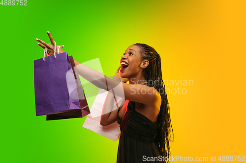 Image of Portrait of young woman in neon light on gradient backgound. The human emotions, black friday, cyber monday, purchases, sales, finance concept.