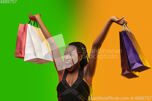 Image of Portrait of young woman in neon light on gradient backgound. The human emotions, black friday, cyber monday, purchases, sales, finance concept.