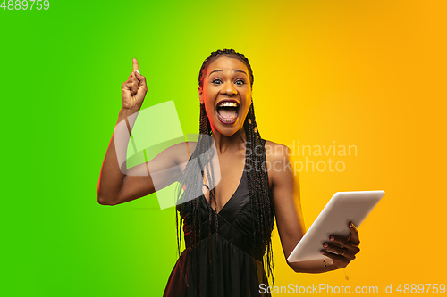 Image of Portrait of young woman in neon light on gradient backgound. The human emotions, black friday, cyber monday, purchases, sales, finance concept.