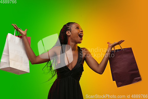 Image of Portrait of young woman in neon light on gradient backgound. The human emotions, black friday, cyber monday, purchases, sales, finance concept.