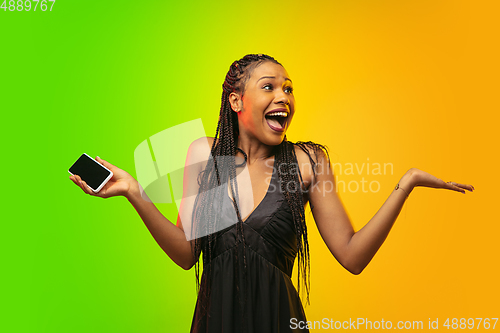 Image of Portrait of young woman in neon light on gradient backgound. The human emotions, black friday, cyber monday, purchases, sales, finance concept.