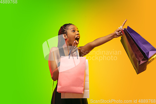 Image of Portrait of young woman in neon light on gradient backgound. The human emotions, black friday, cyber monday, purchases, sales, finance concept.