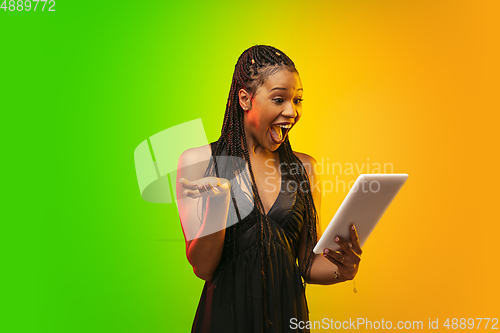 Image of Portrait of young woman in neon light on gradient backgound. The human emotions, black friday, cyber monday, purchases, sales, finance concept.