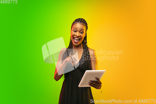 Image of Portrait of young woman in neon light on gradient backgound. The human emotions, black friday, cyber monday, purchases, sales, finance concept.