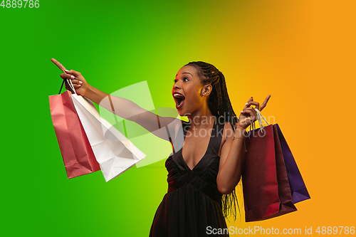 Image of Portrait of young woman in neon light on gradient backgound. The human emotions, black friday, cyber monday, purchases, sales, finance concept.