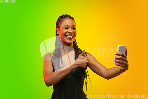 Image of Portrait of young woman in neon light on gradient backgound. The human emotions, black friday, cyber monday, purchases, sales, finance concept.