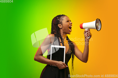 Image of Portrait of young woman in neon light on gradient backgound. The human emotions, black friday, cyber monday, purchases, sales, finance concept.