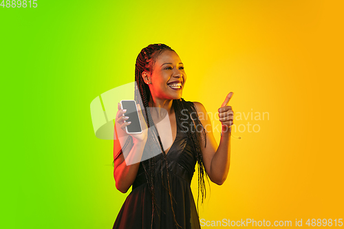 Image of Portrait of young woman in neon light on gradient backgound. The human emotions, black friday, cyber monday, purchases, sales, finance concept.