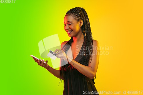 Image of Portrait of young woman in neon light on gradient backgound. The human emotions, black friday, cyber monday, purchases, sales, finance concept.