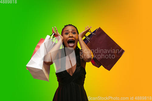 Image of Portrait of young woman in neon light on gradient backgound. The human emotions, black friday, cyber monday, purchases, sales, finance concept.
