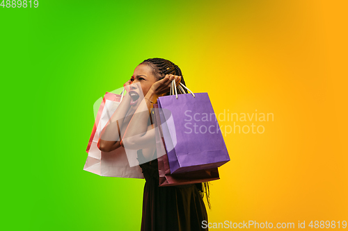 Image of Portrait of young woman in neon light on gradient backgound. The human emotions, black friday, cyber monday, purchases, sales, finance concept.