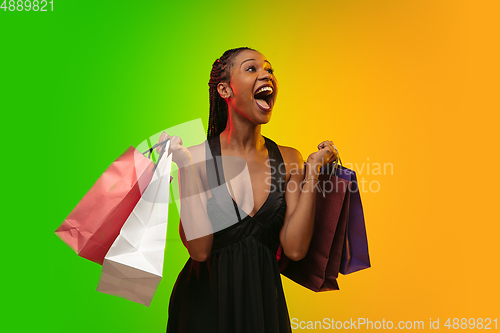 Image of Portrait of young woman in neon light on gradient backgound. The human emotions, black friday, cyber monday, purchases, sales, finance concept.