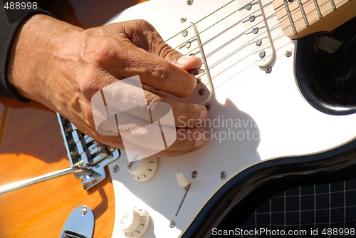 Image of A closeup of a man playing a guitar