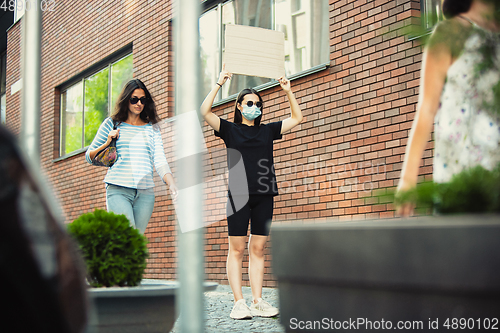 Image of Dude with sign - woman stands protesting things that annoy her