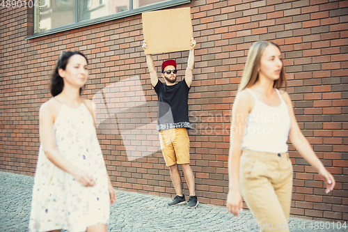 Image of Dude with sign - man stands protesting things that annoy him