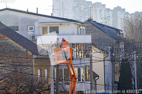 Image of Electrician worker on a pole, repairing power lines