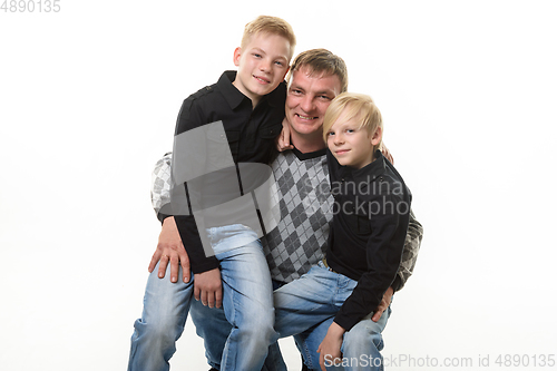 Image of Half-length portrait of a father and two sons in casual clothes on a white background