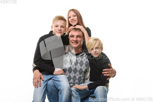 Image of Half-length portrait of a father and three children in casual clothes on a white background