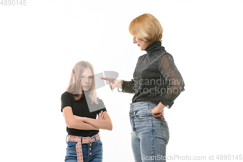 Image of Woman scolding her daughter, upset daughter looks into the frame, close-up portrait