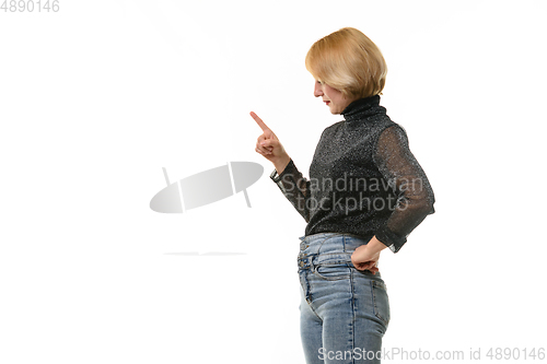 Image of Woman looks to the left and raised her index finger warily, isolated on white background