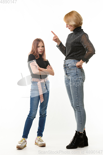 Image of A woman scolds her daughter, an upset daughter looks into the frame