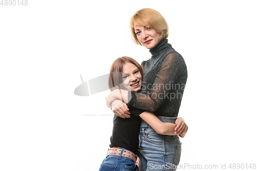 Image of Happy daughter hugs her mother, both look joyfully into the frame, close-up portrait