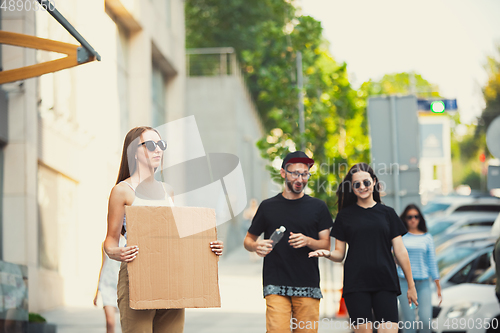 Image of Dude with sign - woman stands protesting things that annoy her