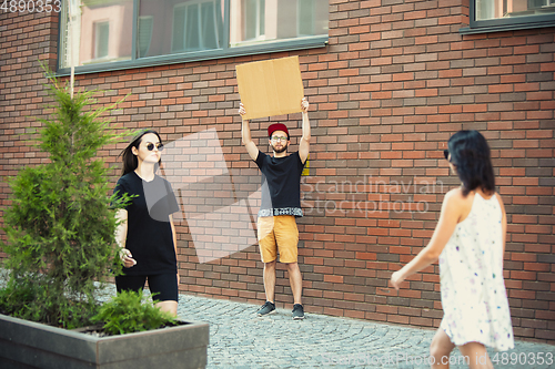 Image of Dude with sign - man stands protesting things that annoy him